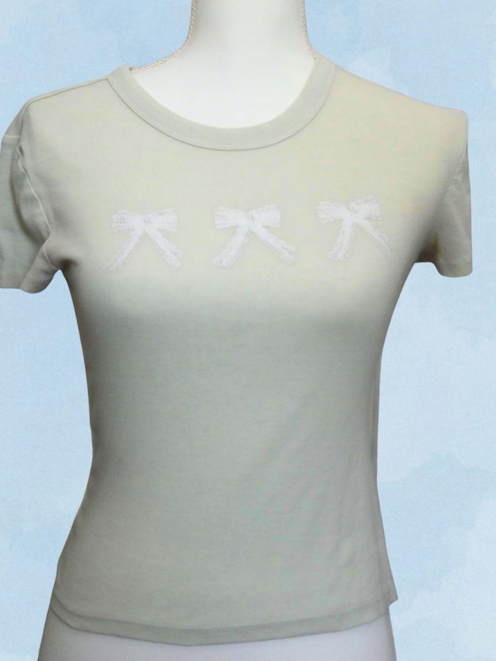 Pale green baby tee with bow graphic
